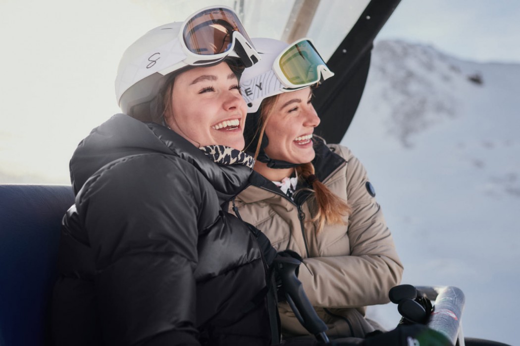 Zwei Damen beim Skilift fahren haben Spaß